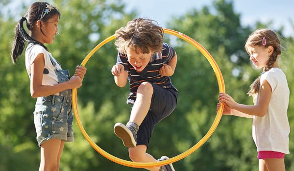 Through hoops. Through hoops. Дети прыгают в обруч. Фотография детская прыжки через обруч. Мальчик прыгает через обруч.